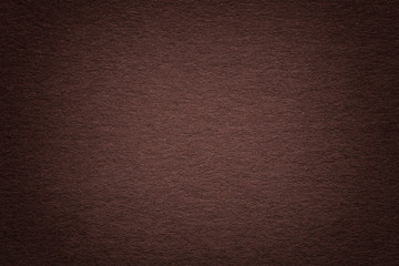 Texture of old dark brown paper background, closeup. Structure of dense beige cardboard.