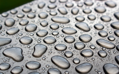 Texture of water drops on stainless steel floor. Close up of rain water drops on iron ground in rainy season.