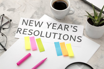 New Year's resolution. text on paper with color stickers and a cup of coffee on a light background.