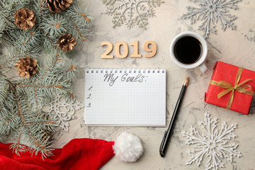 goal 2019. text in notebook with new year decor and christmas tree branches on a light background.