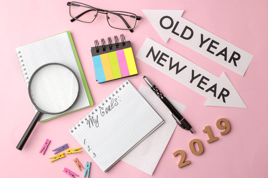 My goals 2019. text in a notebook with colored stickers and a pen, glasses, magnifier on a bright pink background.