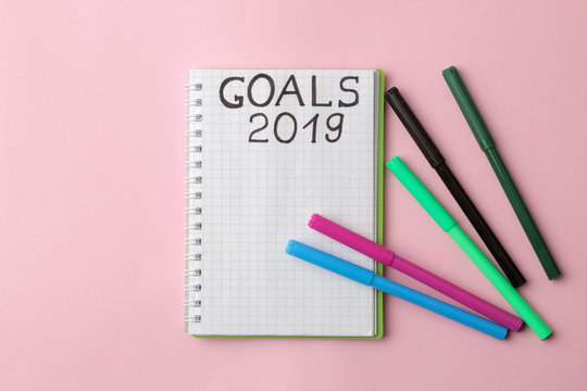 goals 2019. text on a notepad with colored felt-tip pens on a bright pink background.