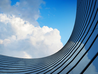 Perspective of high rise building and dark steel window system with clouds reflected on the glass.Business concept of future architecture,lookup to the angle of the building corner. 3d rendering © nuchao