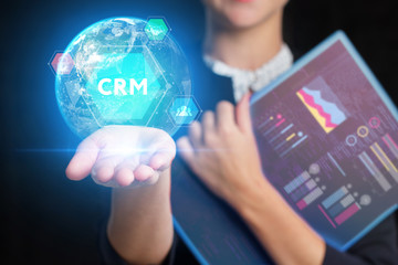 The concept of business, technology, the Internet and the network. A young entrepreneur working on a virtual screen of the future and sees the inscription: CRM