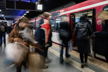 Pendler in der U-Bahnstation steigen in die Bahn ein - obrazy, fototapety, plakaty