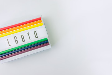 LGBTQ word on light box and Color pencils on white background.LGBTQ is Lesbian, Gay, Bisexual, Transsexual, Queer.