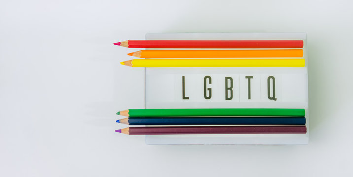 LGBTQ word on light box and Color pencils on white background.LGBTQ is Lesbian, Gay, Bisexual, Transsexual, Queer. - Powered by Adobe