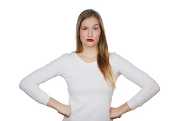 Fototapeta premium Junge Frau stemmt die Händen in die Hüften und schaut skeptisch