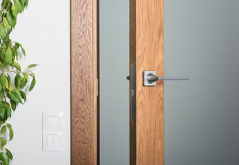 Zbliżenie uchylonych drzwi. Klamka stalowa, ciemne drewno z fakturą - 237405195