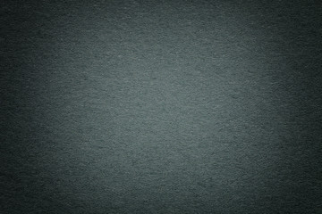 Texture of old dark green paper background, closeup. Structure of dense deep bluish cardboard.