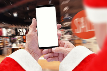 Santa Claus holding phone with empty screen, clothing store in background