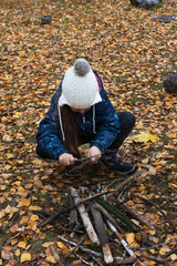 Сhild make a fire in the forest