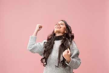 I won. Winning success happy woman celebrating being a winner. Dynamic image of caucasian female model on pink studio background. Victory, delight concept. Human facial emotions concept. Trendy colors