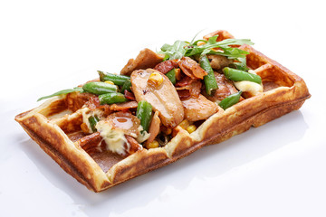 Belgian waffle on a white background. Stuffed with chicken, asparagus and arugula