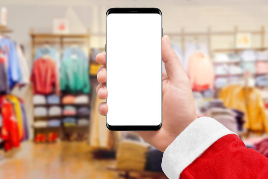 Santa Claus holding smartphone with empty screen in cloth store