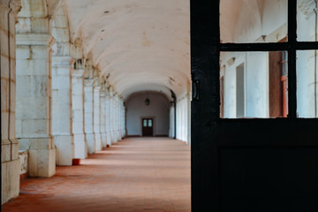 Fototapeta na wymiar Pillar lined corridor with selective focus on doorway