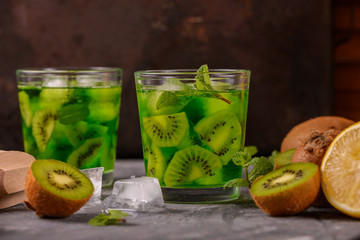 Cocktail with kiwi and mint in a glass on a wooden background. Selective focus. Homemade lemonade with kiwi