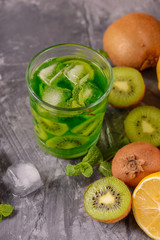 Cocktail with kiwi and mint in a glass on a wooden background. Selective focus. Homemade lemonade with kiwi