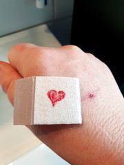 Pflaster auf Hand mit Herz