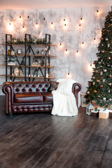Christmas or New Year background: lamps, green cristmas tee, brown sofa, gifts
