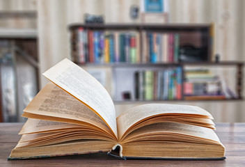 expanded book, blurred background bookshelf