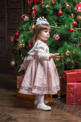 Little cute girl near Christmas tree.