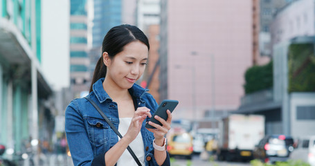 Woman check on mobile phone in the street