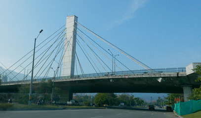 Fototapeta na wymiar El Poblado and suspension bridge over Medellin river in Medellin, Colombia