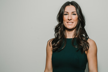 Beautiful, young and successful business woman on gray background with copy space. Confident young manager. Lifestyle.