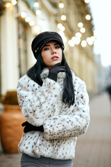 Outdoor portrait of fashionable dressed young model posing at the street