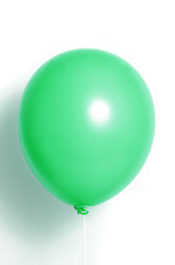 Green balloon on white background with shadow. Side glare.