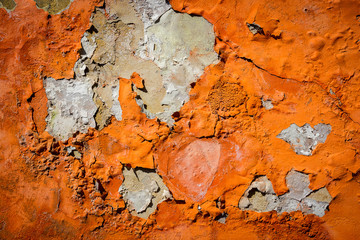 Orange plaster peeling off an old wall
