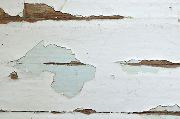 Old shabby, breakaway white paint from the wooden structure in the apartment. Old paint layers