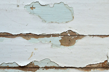 Old shabby, breakaway white paint from the wooden structure in the apartment. Old paint layers