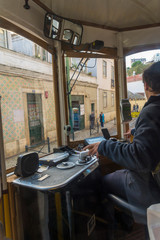 LISBON, PORTUGAL - NOVEMBER 21, 2018: Driver of a tram of the popular line 28. Line 28 passes through the most touristic places of Lisbon