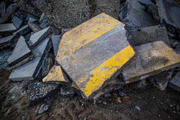 rubble pile of asphalt with the yellow paint of pedestrian stripes