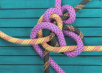 Knot on a colorful cord  on wooden background