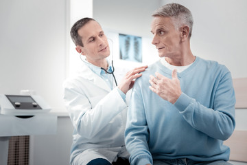 Fototapeta premium Delighted medical worker calming his visitor