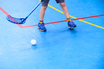 Floorball child boy player with stick and ball. Children playing florball sport