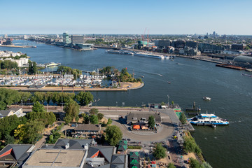 Fototapeta premium View Dutch harbor Amsterdam with marina, ferry and apartment buildings