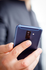 Male hand holding a cell smartphone and writing sms