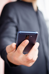 Male hand holding a cell smartphone and writing sms