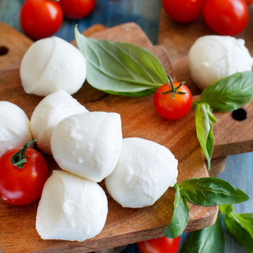 Italian cheese mozzarella with tomatoes, olive oil and herbs
