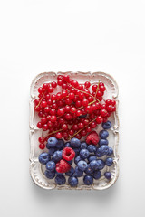 Healthy breakfast made of raspberries, red currants and blueberries viewed from above. Top view. Copy space.