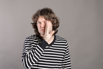 Secret gossip concept. Young man whispering secret confidential info behind her hand. Hipster...