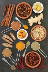 Fototapeta na wymiar Spices for losing weight with turmeric, cumin, ginger, chilli, cinnamon and gymnema sylvestre used to suppress appetite. Top view on slate background.