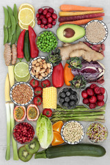 Super food concept for good health with fresh fruit and vegetables, herbs, spices, nuts, seeds, legumes, grains, with foods high in antioxidants, anthocyanins, dietary fibre and vitamins.