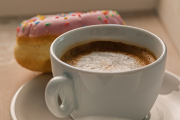 Coffee and doughnut in the morning light.