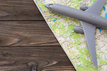 model airplane on the map on the background of a wooden table. tourism, travel