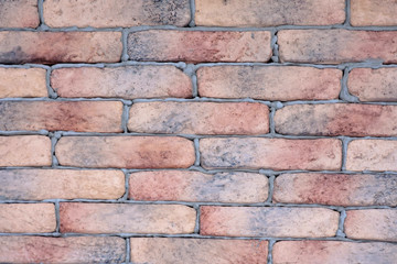 Background with old brick wall of aged gray and red bricks with concrete. Natural stone surface with rough texture and selective focus. Decorate abstract wallpaper with structure granite rocks.